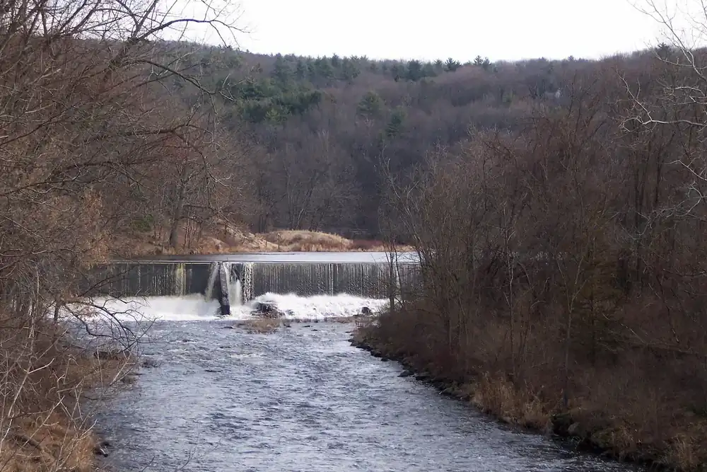 The Millers River flowing over a low dam between wooded banks in Athol, Massachusetts