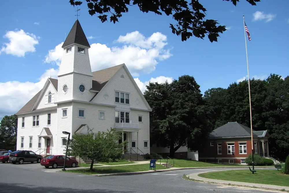 The white Auburn Town Offices and the brick Merriam Library in Auburn, Massachusetts