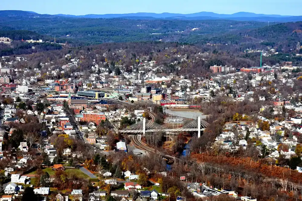 Aerial view of Fitchburg, Massachusetts, with downtown, rail lines and hills beyond in autumn