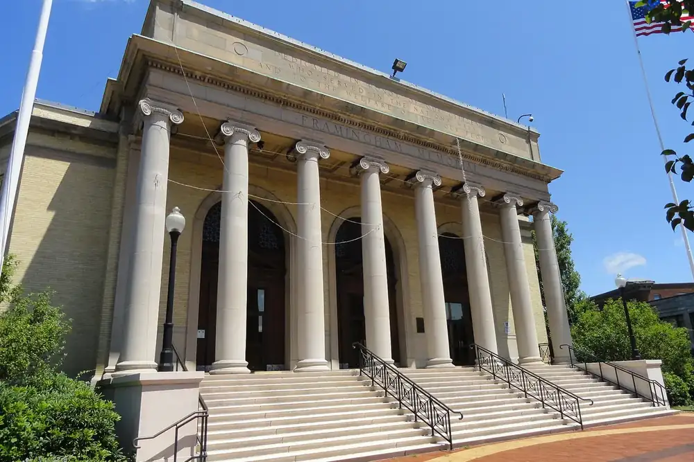 The columned stone Framingham Memorial Building and its front steps under a blue sky