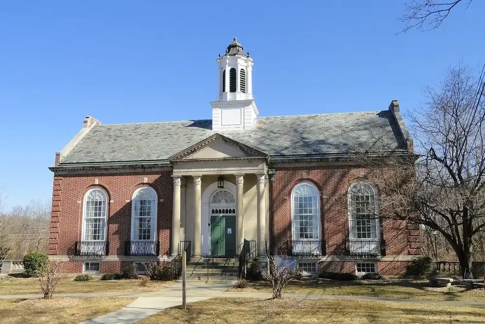 The brick Grafton Public Library with white columns and a cupola in Grafton, Massachusetts
