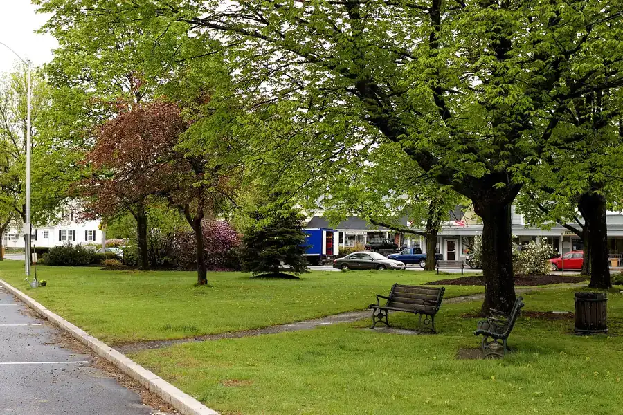 Benches and shade trees on the grassy town common in Littleton, Massachusetts