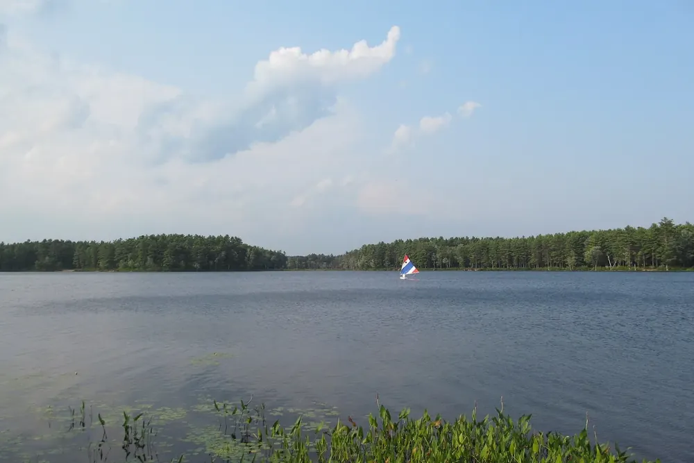 Calm water and a wooded shoreline at Lake Dennison in Winchendon, Massachusetts
