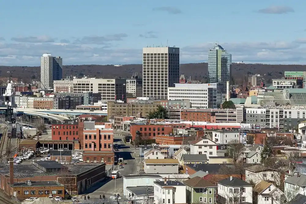 The Worcester, Massachusetts skyline above brick neighborhoods and rail lines on a clear day